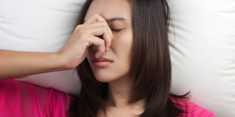 ragazza che si tocca il naso dal dolore